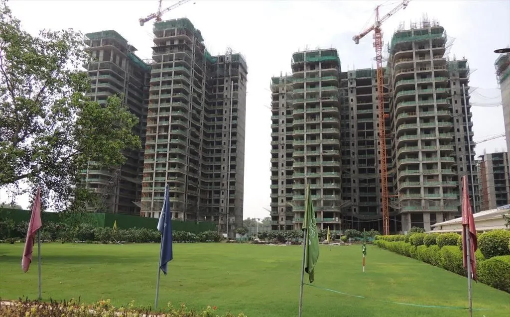 Residential towers under active construction with cranes and safety netting — risks of buying property in Dubai